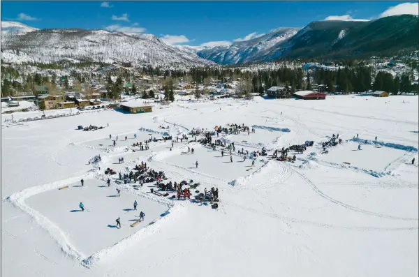  ?? (AP/Brittany Peterson) ?? Athletes compete Feb. 26 at a pond hockey tournament in Grand Lake, Colo. The event, which takes place on the state’s largest natural lake, was held a month later than normal due to a delayed freeze following a trend of extremely hot summers and an uncharacte­ristically warm fall.