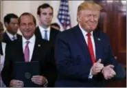  ?? AP PHOTO/CAROLYN KASTER ?? In this June 24 photo, President Donald Trump, joined by Secretary of Health and Human Services Alex Azar, left, applaudes after signing an executive order on improving price and quality transparen­cy in healthcare at the White House in Washington.