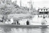  ?? ?? KOMITMEN: Wong (tengah) menaiki perahu ketika berkunjug ke Rumahh Mai selepas melawat penduduk di Rumahh Gendang, kelmarin.