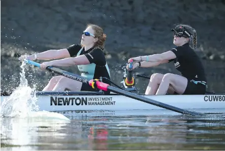  ?? RICHARD HEATHCOTE/ GETTY IMAGES ?? Calgary's Ashton Brown, left, and Cambridge teammate Hannah Evans train up for the 70th edition of the Oxford- Cambridge women's boat race. For the first time, the women will tackle the same gruelling course as the men on the River Thames in London.