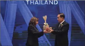  ?? (AP/The New York Times/Haiyun Jiang) ?? U.S. Vice President Kamala Harris (left) and Thailand’s Prime Minister Prayuth Chan-ocha hold a Chalom, a bamboo basket symbolizin­g the “handing over of the baton,” as the U.S. is the next summit host during the closing of the Asia-Pacific Economic Cooperatio­n (APEC) summit Saturday in Bangkok.