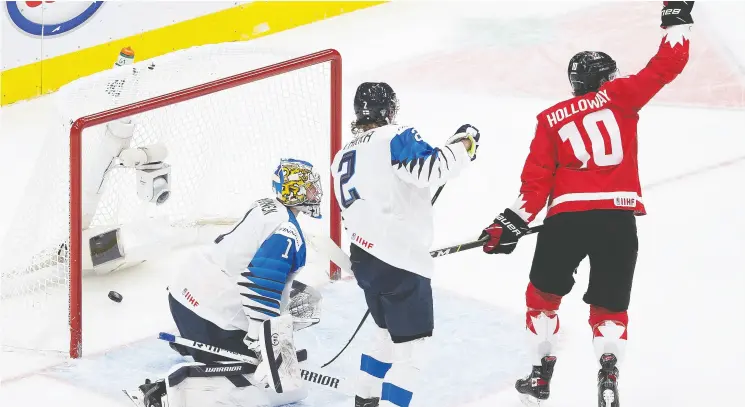  ?? Photos: Greg Southam / Postmedia News ?? Canada’s Dylan Holloway celebrates a goal as Finland goaltender Kari Piiroinen looks on during Thursday’s game in Edmonton.