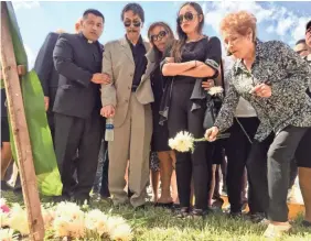  ?? ALAN GOMEZ/USA TODAY ?? Relatives of the victims of a bridge collapse at Florida Internatio­nal University lay flowers on a memorial after a campus vigil Wednesday.