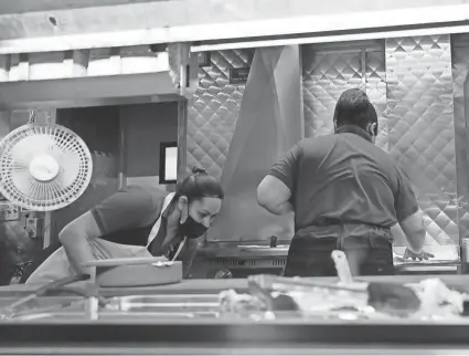  ?? ?? Women work in a restaurant kitchen March 23 in Chicago. The labor market has added jobs at a steady clip in the past year, despite efforts by the Federal Reserve to cool the economy and bring down inflation. NAM Y. HUH/AP FILE