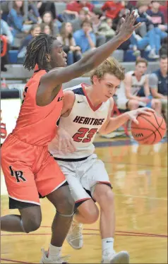  ?? / Michelle Petteys, Heritage Snapshots ?? Lafayette’s Tyrese Marsh attempts to guard Heritage’s Clint Petteys on a drive in the lane.