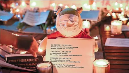  ?? California. — AFP ?? Can’t bear with it anymore: a Winnie the Pooh soft toy is seen wrapped in a face mask while holding a placard during a protest against China’s zero-covid policies at the University of California berkeley campus in berkeley,