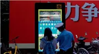  ?? — AFP ?? A traffic policeman explains to a girl about the installed facial recognitio­n screen at a road intersecti­on in Shanghai.