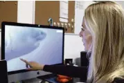  ?? CALEB JONES AP ?? Ocean Ramsey, co-founder of One Ocean Diving and Research, reviews footage of her encounter with the shark.