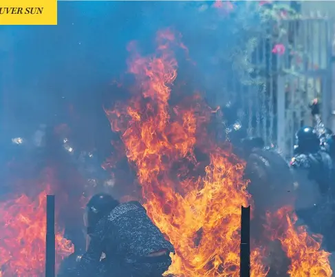  ?? JUAN BARRETO / AFP / GETTY IMAGES ?? Two police motorbikes burn after being hit by an improvised explosive device placed by anti-government activists during a protest in Caracas against the Venezuelan election on Sunday. Deadly violence erupted nationwide in the wake of the controvers­ial...