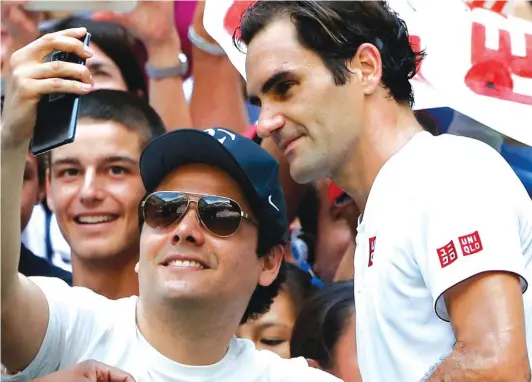 ??  ?? Roger Federer, of Switzerlan­d, poses with a fan after defeating Nick Kyrgios Photo: AP