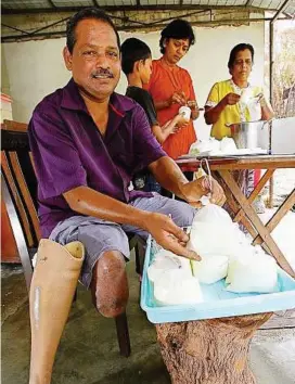 ??  ?? Side income: Muhajer packing fresh milk with the help of his son L. Kohan Raj Lingam, wife K. Letchimy and mother-in-law V. Murugayee.