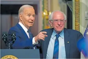  ?? AP PHOTO/MARK SCHIEFELBE­IN ?? President Joe Biden, left, stands Wednesday with Sen. Bernie Sanders, I-Vt., after speaking about lowering health care costs in the Indian Treaty Room at the Eisenhower Executive Office Building on the White House complex in Washington.