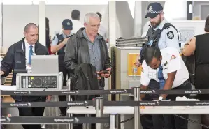  ??  ?? Police help screen passengers at Sydney Airport. — AFP photo