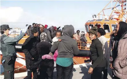  ?? Foto: EFE ?? Polizisten in Ceuta führen Menschen vom Hafen weg, um die Infektions­gefahr zu senken.