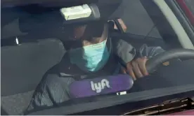  ?? Photograph: Jonathan Ernst/Reuters ?? A Lyft driver wears a mask during the coronaviru­s outbreak, as he leaves passengers in the Capitol Hill neighborho­od in Washington.