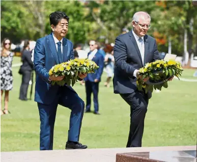  ?? — AP ?? Healing wounds: Abe with Morrison about to lay wreaths at the Cenotaph War Memorial in Darwin.