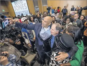  ?? WELSH/THE MONTGOMERY ADVERTISER] [MICKEY ?? U.S. Sen. Cory Booker, D-N.J., and Democratic U.S. Senate candidate Doug Jones take selfies with supporters during a rally Saturday at Alabama State University in Montgomery.