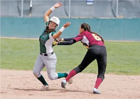  ?? LUIS SÁNCHEZ SATURNO/THE NEW MEXICAN ?? West Las Vegas High School’s Elena Archuleta, left, is tagged by Santa Fe Indian High School’s Kiera Mermejo-Varga during the top of the second inning of Wednesday’s game during the Class 4A State Softball Tournament at Cleveland High School.