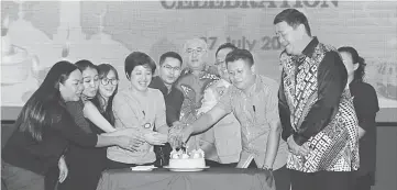  ??  ?? Yii (sixth left) and Lai (second right) join NSJA members cut the birthday cake for those with birthdays from April to September.