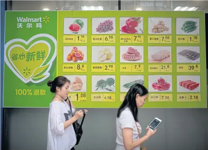  ?? AP ?? A billboard displays prices for fresh produce outside a Walmart store in Beijing. Thai officials will meet US counterpar­ts this week to voice concerns over the fallout from the China-US trade spat.