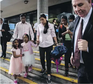  ?? ANTHONY WALLACE / AFP / GETTY IMAGES ?? Lawyer Robert Tibbo, right, gathers his clients, the two families who sheltered fugitive whistleblo­wer Edward Snowden in Hong Kong, who are facing deportatio­n after the city’s authoritie­s rejected their bid for protection.