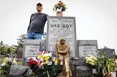  ?? JIM NOELKER / STAFF ?? Jim Skaggs stands near the grave of Sgt. Gary McKiddy at Highland Memorial Cemetery in Miamisburg. Both men served in Vietnam. McKiddy rescued Skaggs from a burning helicopter and died when the helicopter exploded 52 years ago.