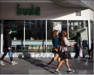  ?? THE CANADIAN PRESS/DARRYL DYCK ?? People walk past a Freshii restaurant in Burnaby, B.C., on Oct. 9. The CEO of healthy fast-food chain Freshii says bottleneck­s in new markets, delays from major franchise operators and the setback at outlets in Target stores combined to force the...