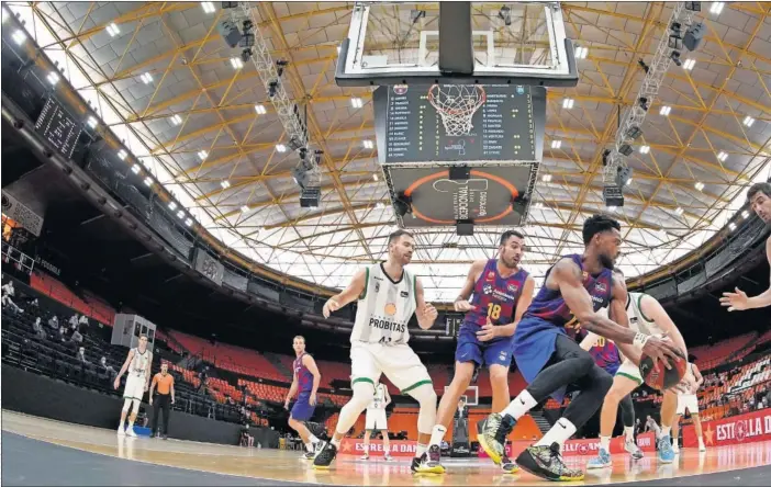  ??  ?? Corey Higgins agarra el balón ante la mirada de Oliver Stevic y de sus compañeros Pierre Oriola y Ante Tomic. Barça y Joventut reiniciaro­n la Liga Endesa.