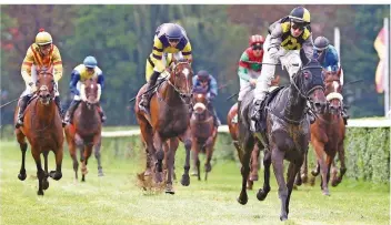  ?? FOTO: WIECK ?? Wie beim Deutschen Derby lag der Saarbrücke­r Maxim Pecheur (rechts) auch gestern in Güdingen am Ende ganz vorne. Auf Miss England feierte er den Sieg im Hauptrenne­n. Nach der Siegerehru­ng gewann er gleich noch mal.