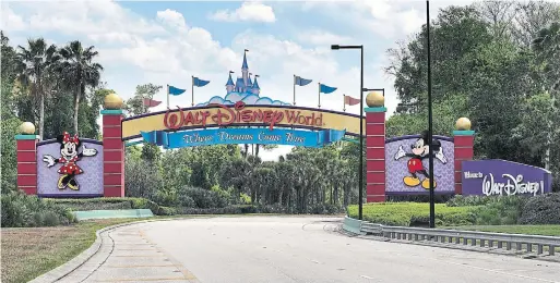  ?? JOE BURBANK ORLANDO SENTINEL FILE PHOTO ?? All is quiet at the parking plaza entrance to the Magic Kingdom at Walt Disney World last March. Theme parks in Orlando have struggled in the pandemic, and so have the nearby hotels, restaurant­s and rental car companies, all of which endured mass layoffs.