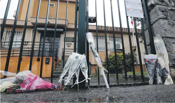  ?? Reuters; AP ?? Tributes to Arnaud Beltrame at Carcassonn­e Gendarmeri­e. Lights were dimmed at Paris landmarks to mark the bravery of the officer, below