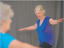  ??  ?? Instructor Sharon Steffensen (left) conducts “Grandma Yoga” class.