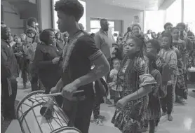  ?? KARL MERTON FERRON/THE BALTIMORE SUN ?? Drummers march through the crowd Saturday during the Kwanzaa celebratio­n. The Reginald F. Lewis Museum has held similar events for at least six years.