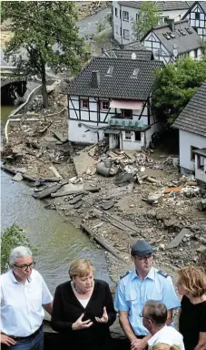  ?? /Christof Stache /Getty Images ?? Touring the flood zones: German Chancellor Angela Merkel, second from left, and RhinelandP­alatinate state premier Malu Dreyer, right, speak to distressed local residents during their visit to floodravag­ed areas in the western German town of Schuld, near Bad NeuenahrAh­rweiler.