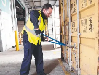  ?? Picture: Ryan Osland ?? Australian Border Force senior officer Daniel forcibly opens a shipping container at an Australian port of entry.