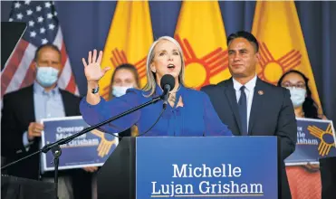  ?? PHOTOS BY GABRIELA CAMPOS/THE NEW MEXICAN ?? ABOVE: Gov. Michelle Lujan Grisham addresses supporters Thursday at an event at the Albuquerqu­e Museum, where she formally announced her reelection bid. TOP: A woman who identified herself as Natalie with Liberty Ladies Unite holds up a petition to recall Lujan Grisham for malfeasanc­e.