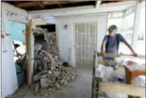  ?? MARCIO JOSE SANCHEZ — THE ASSOCIATED PRESS ?? Eugene Johnson, right, looks at the chimney collapsed by an earthquake Saturday at his home in Trona, Calif.