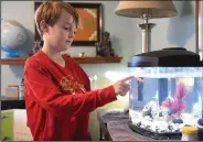  ?? (AP/Detroit News/Robin Buckson) ?? Declan points to a fish in the tank he got for his birthday in October.