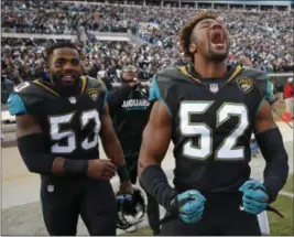  ?? STEPHEN B. MORTON — THE ASSOCIATED PRESS ?? Jaguars linebacker­s Donald Payne (52) and Blair Brown (53) celebrate after defeating the Bills on Jan. 7 in Jacksonvil­le, Fla.