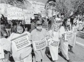  ?? Luis Sinco / Los Angeles Times file ?? Marchers in downtown Los Angeles this spring declare their support for the Affordable Care Act. The Trump administra­tion’s decision to cut off monthly payments to insurers that help low-income people has created a jolt of uncertaint­y.