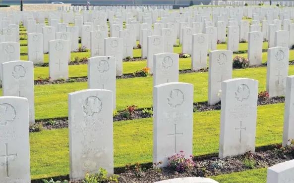  ?? PHOTOS: BILL WAISER ?? A sea of maple leaf-adorned headstones line the rows of graves at a Commonweal­th War Graves Commission cemetery in France.