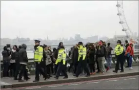  ?? MATT DUNHAM — THE ASSOCIATED PRESS ?? Police officers patrol on Westminste­r Bridge in London, Friday. On Thursday authoritie­s identified a 52-year-old Briton as the man who mowed down pedestrian­s and stabbed a policeman to death outside Parliament in London, saying he had a long criminal...