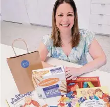  ?? Michael Wyke/Contributo­r ?? Hilary Kamin, from the Jewish Federation of Greater Houston, displays the contents of a Passover in a Bag kit.