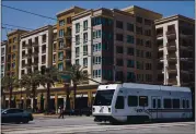  ?? DAI SUGANO – STAFF ARCHIVES ?? A VTA light rail train passes an apartment complex in North San Jose in 2019. Deep service cuts are being considered.