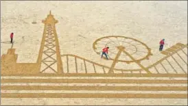  ?? AFP ?? An aerial photo shows a giant sand art, depicting the iconic Pier Tower and rides of Blackpool in England. It was drawn by artists to promote tourism following the end of Covid-19 restrictio­ns.