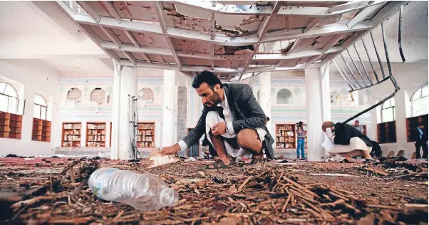  ?? Photo: REUTERS ?? Crime scene investigat­ors study the floor of a mosque after
the suicide bombing that killed at least 126 people in Sanaa, capital of Yemen.