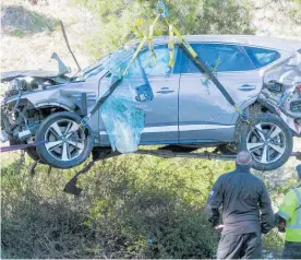  ?? Photo / AP ?? The crumpled SUV Tiger Woods was driving when he crashed at speed is lifted from the scene in February.