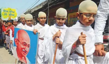  ?? AFP ?? Indian school children dressed as Mahatma Gandhi take part in a march on the eve of Gandhi Jayanti celebratio­ns, in Amritsar yesterday. Gandhi Jayanti is celebrated today.