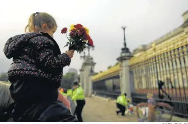  ?? OLIVIER HOSLET / EFE ?? Una niña sostiene un ramo de flores ante el Palacio de Buckingham.