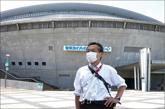  ?? (AP/Chisato Tanaka) ?? Olympic volunteer Atsushi Muramatsu poses for a photo Thursday in front of Sekisui Heim Super Arena, which was used as a morgue after the 2011 earthquake, also known as the Great East Japan Earthquake, in Rifu, Japan.